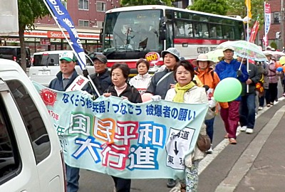 道内通し行進者の鈴木さん（前列左）、吉岡さん（前列右）らを先頭に行進する平和行進清田区コースの人たち